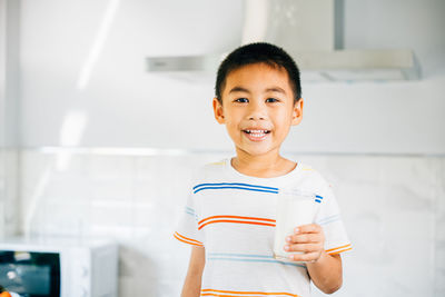 Portrait of boy standing against wall