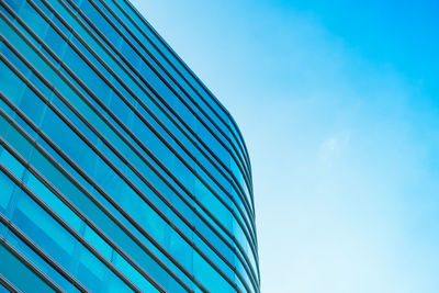 Low angle view of modern building against blue sky