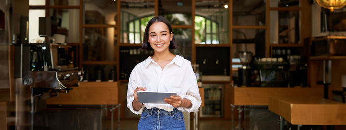 Portrait of young woman standing in library