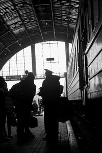 Rear view of people walking on railroad station