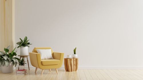 Modern minimalist interior with yellow armchair on empty white wall.3d rendering