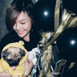 Portrait of young woman with dog at home