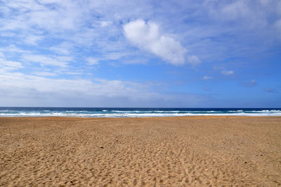 Scenic view of sandy beach against sky