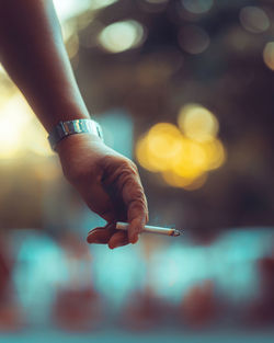 Close-up of hand holding cigarette