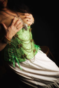 Midsection of woman wearing mask against black background