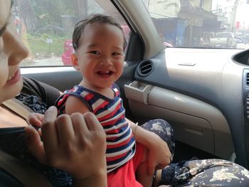 Close-up of cute girl sitting in car