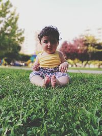 Cute boy sitting on field