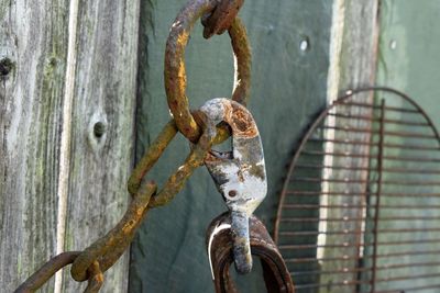 Close-up of rusty chain hanging on metal door