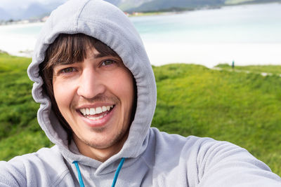 Tourist man making selfie on rambergstranda beach on lofoten islands. beautiful sandy beach. norway.