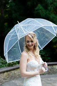 Young woman with umbrella standing in rain