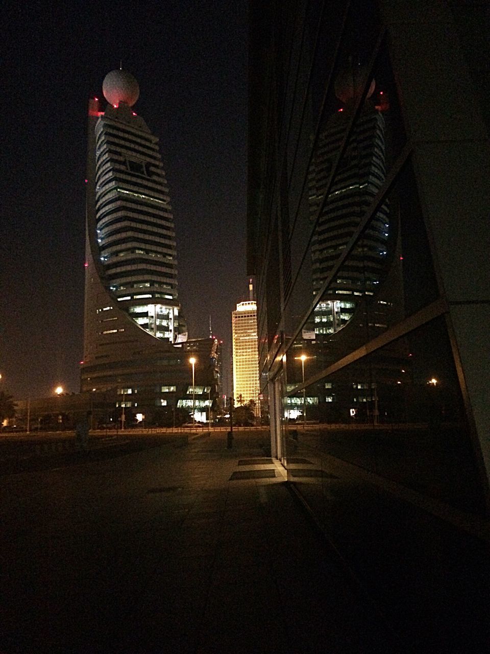 illuminated, architecture, built structure, night, building exterior, city, modern, skyscraper, tall - high, tower, office building, the way forward, capital cities, clear sky, lighting equipment, street light, travel destinations, bridge - man made structure, sky, city life