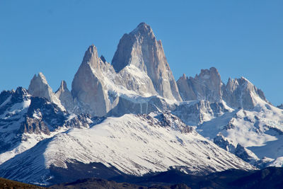 Scenic view of snowcapped mountains against clear blue sky