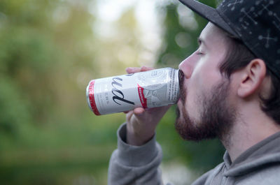 Portrait of young man drinking glasses outdoors