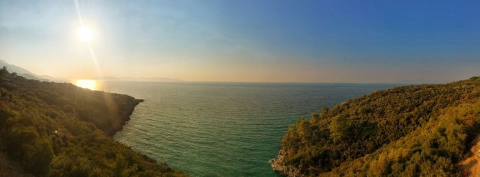 Scenic view of sea and mountains against sky