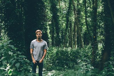 Portrait of young man standing in forest