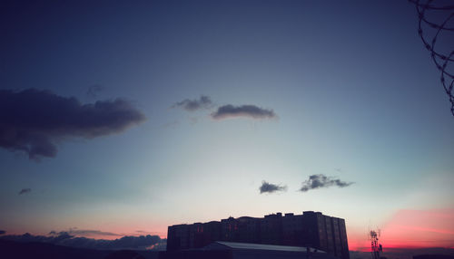 Low angle view of silhouette buildings against sky at sunset