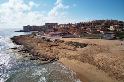 Panoramic view of sea and buildings against sky