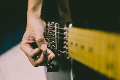 Midsection of man playing guitar