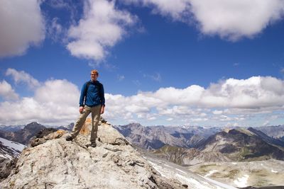 Hiker standing on mountain against sky