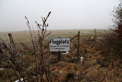 Information sign on landscape against clear sky