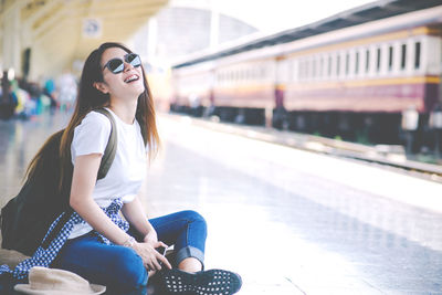 Young woman wearing sunglasses sitting in bus