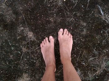 Person standing barefoot on muddy grounds