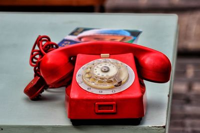 Close-up of red telephone on table