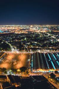 High angle view of illuminated cityscape against sky at night
