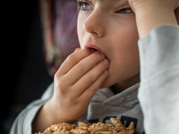 Close-up of bored boy eating biscuits at home