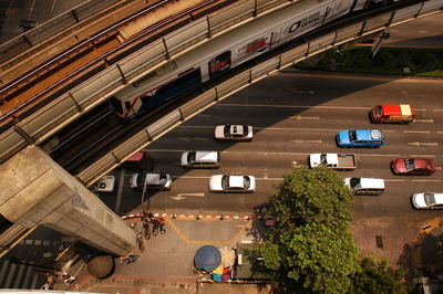 High angle view of train on bridge over cars moving on road