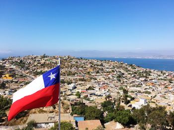 High angle shot of chile flag against townscape against blue sky