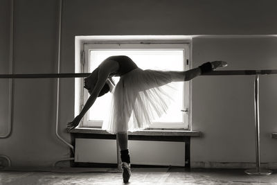 Full length of young ballet dancer balancing on floor