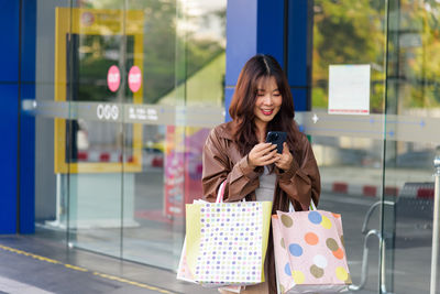 Portrait of young woman using phone