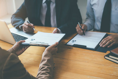 Midsection of man using mobile phone on table