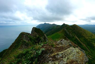 Scenic view of sea and mountains against sky