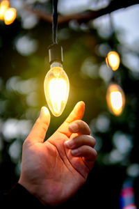 Close-up of hand holding light bulb