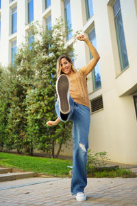 Full length of young woman standing on footpath