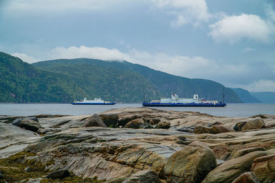 Scenic view of sea and mountains against sky