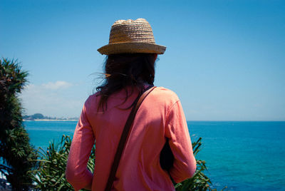 Rear view of woman wearing hat against clear sky