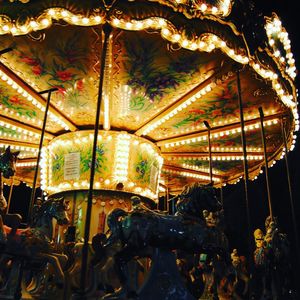 Low angle view of illuminated carousel at night