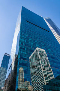 Low angle view of modern buildings against clear blue sky