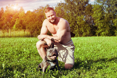 Portrait of young woman with dog on field