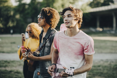 Young men playing ukulele while enjoying in music festival