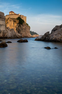 Rock formations by sea against sky