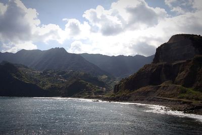 Scenic view of sea and mountains against sky