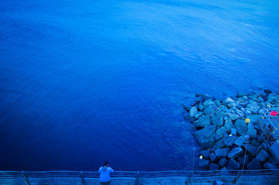 High angle view of man standing at observation point over sea