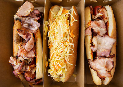 American hot dog with different flavors, with cheese and crispy onions on a white table