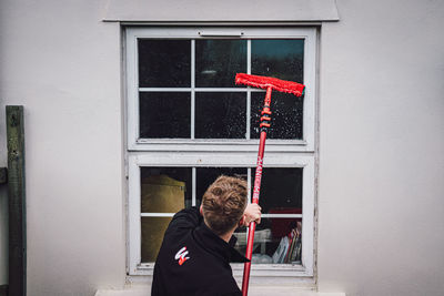 Man standing by window of building