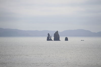 Scenic view of sea and mountains against sky