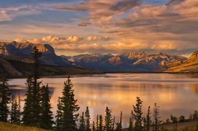 Scenic view of lake and mountains against sky during sunset